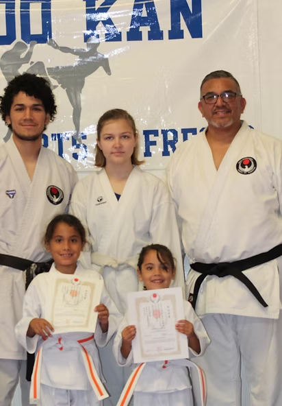 A group of people standing in front of a banner that says ju kan