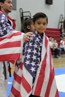 A young boy is wrapped in an american flag