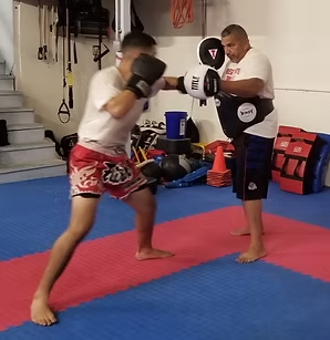 A man wearing everlast boxing gloves is boxing another man