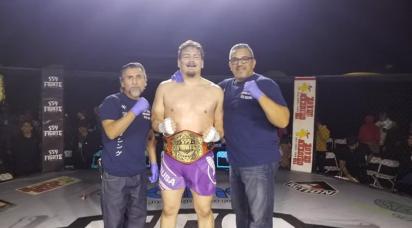 A man in purple shorts is posing for a picture with two men in blue shirts.