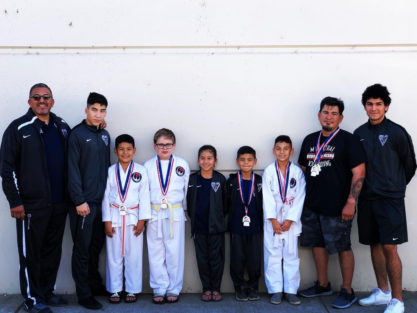 A group of young boys standing next to each other with medals around their necks