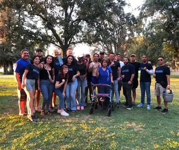 A group of people are posing for a picture in a park.