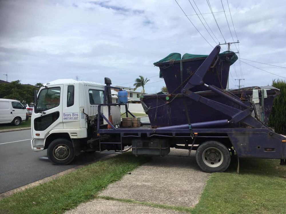 A Dump Truck Is Parked On The Side Of The Road Next To A Sidewalk — Bears Bins Skip Hire In Meridan Plains, QLD