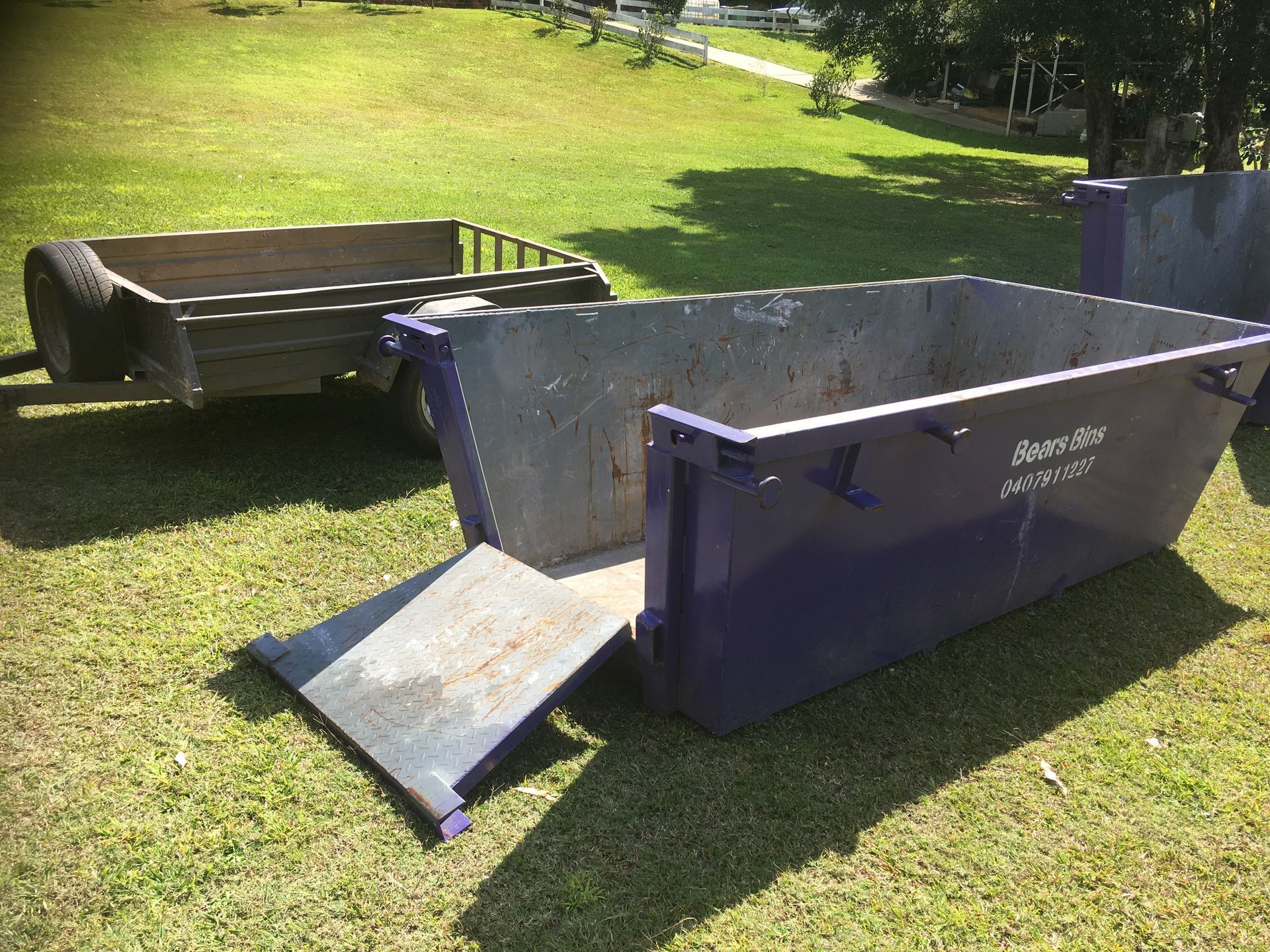 A Dumpster Is Parked On The Side Of The Road Next To A Car — Bears Bins Skip Hire In Meridan Plains, QLD