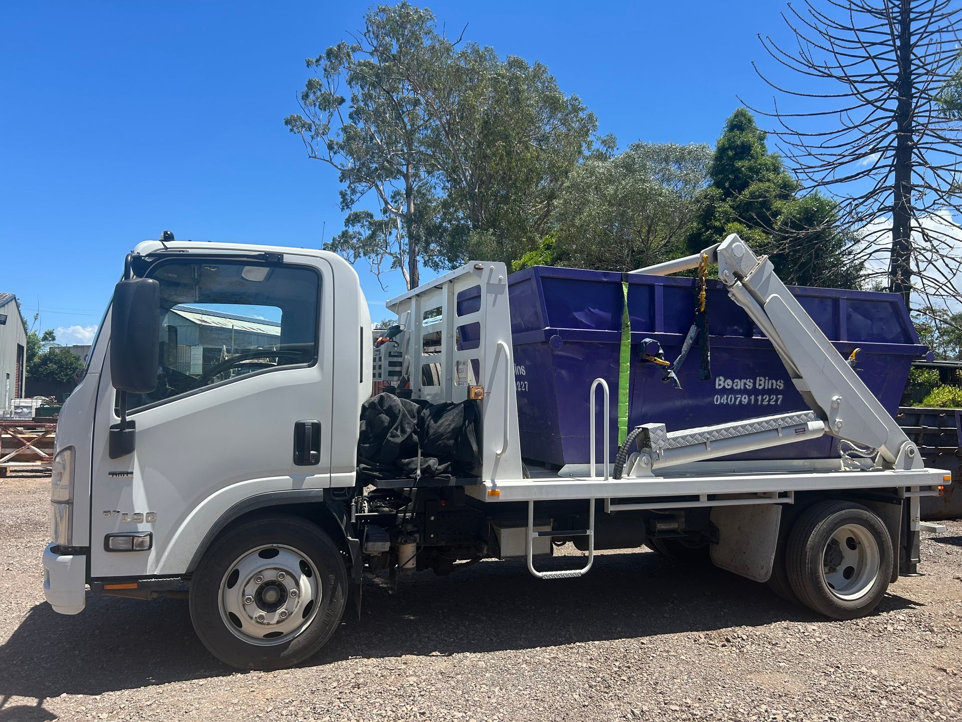 White truck with a blue dumpster on a sunny day — Bears Bins Skip Hire In  Meridan Plains, QLD
