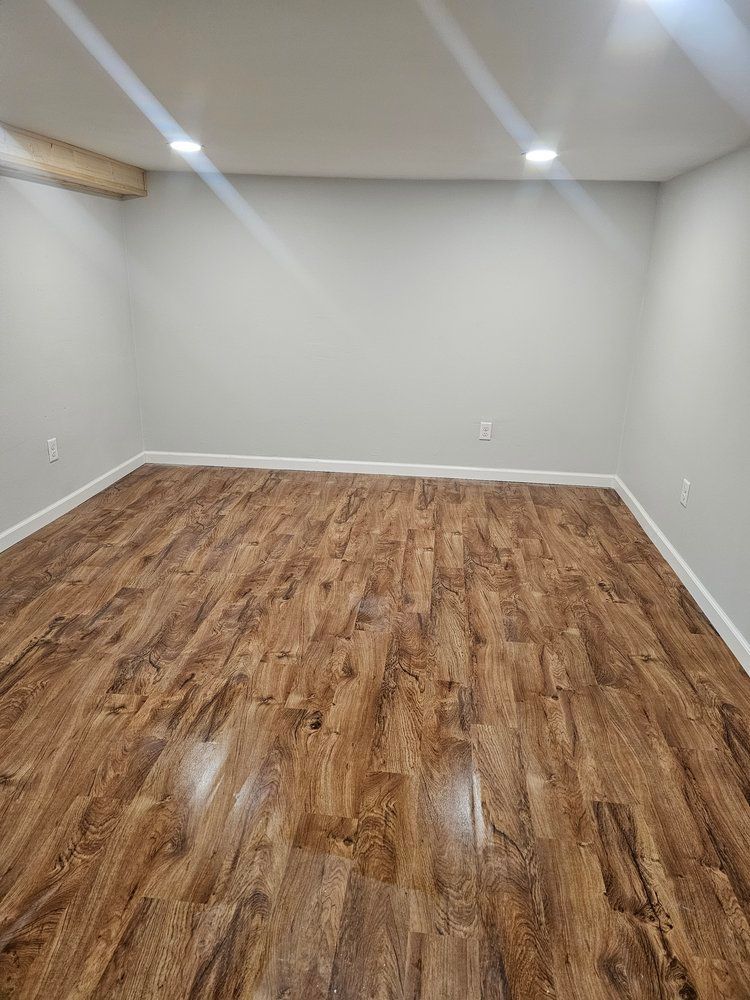 An empty room with wooden floors and white walls.