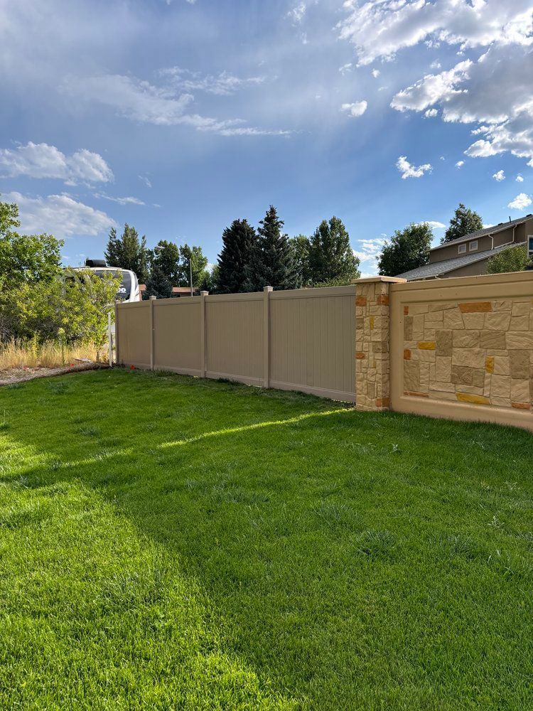 There is a fence in the middle of a lush green field.