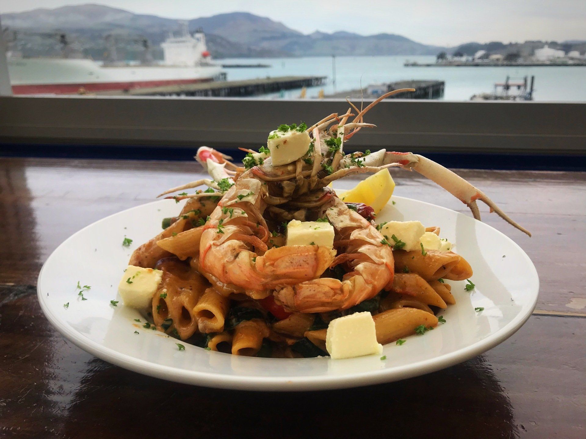 A plate of pasta with shrimp and cheese on a table
