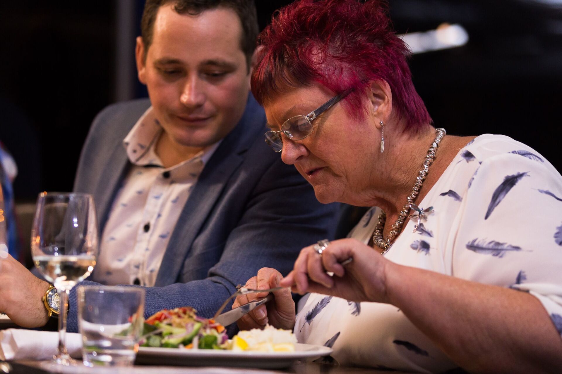 A man and a woman are sitting at a table eating food.