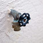 Water,Spigot,With,Backflow,Preventer,Valve,On,Stucco,Wall