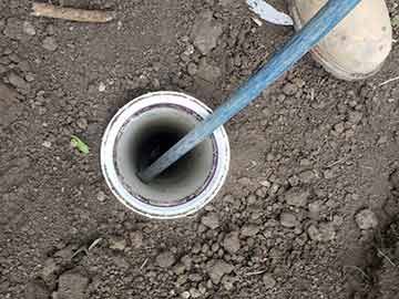 A person is digging a hole in the ground with a shovel.