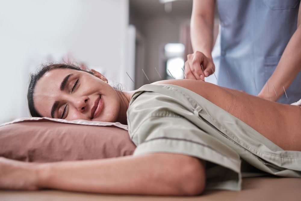 Person lying on a massage table while a therapist massages their back