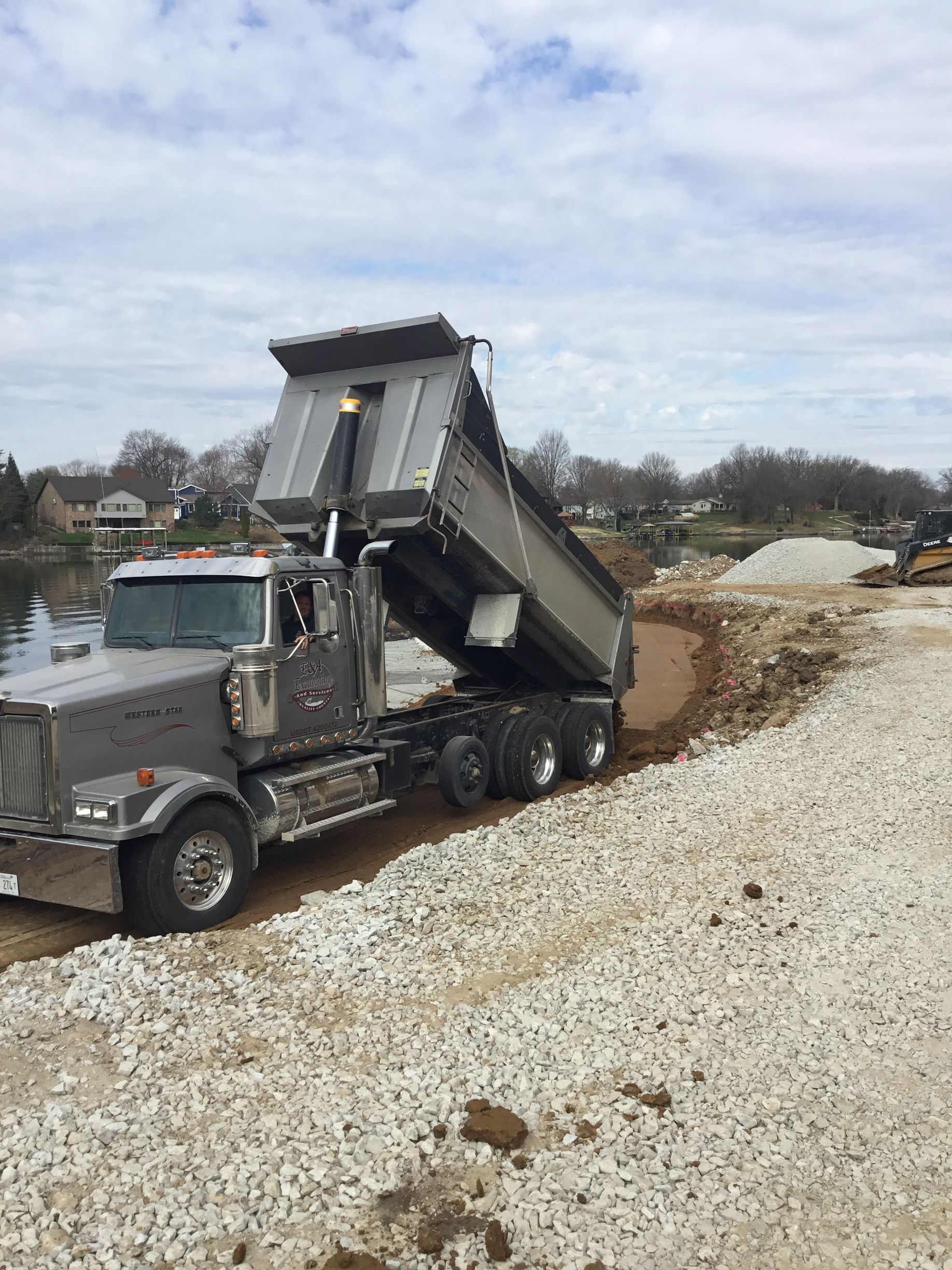 A dump truck is sitting on top of a pile of gravel.