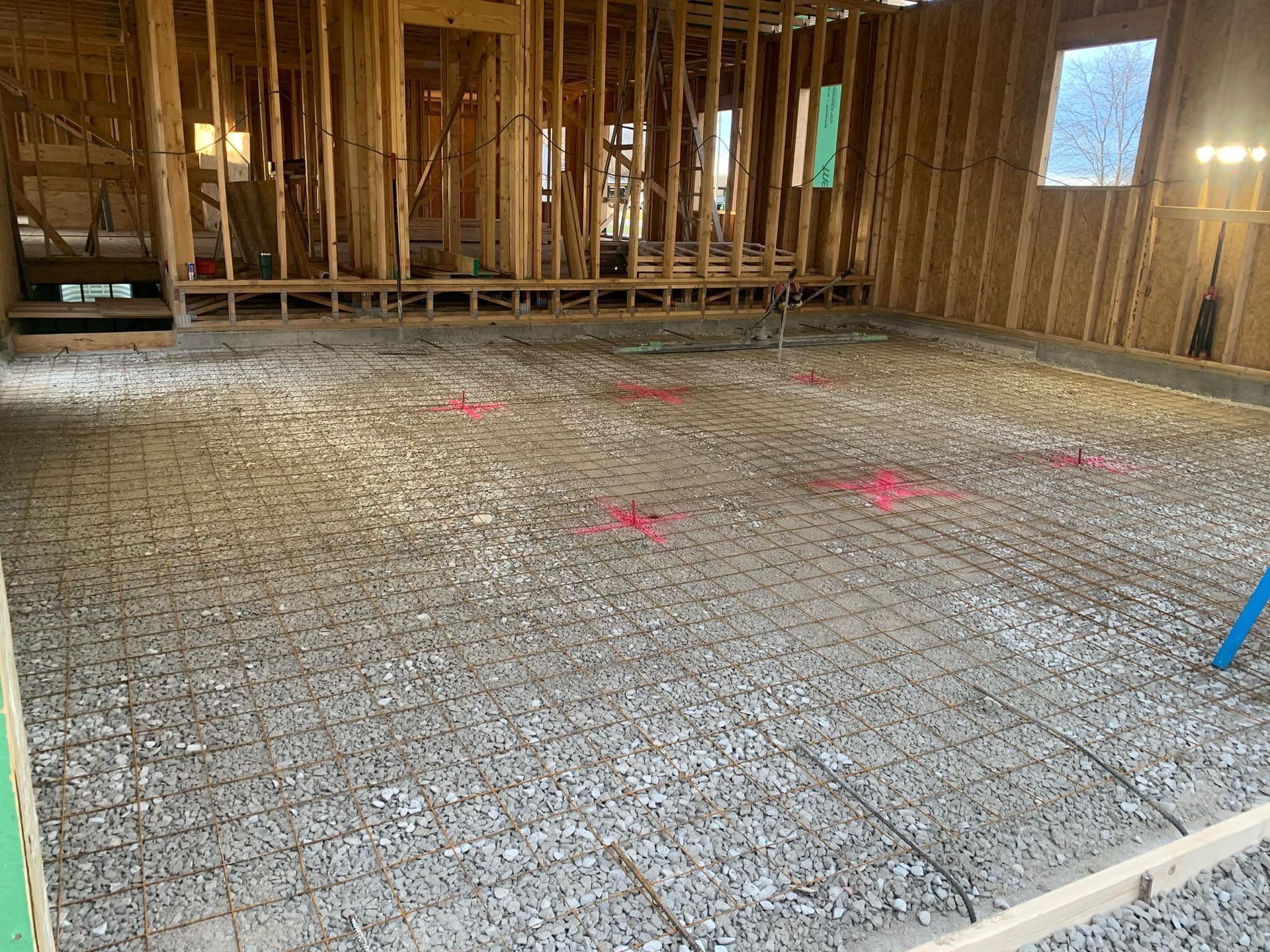 A room under construction with a concrete floor and a wooden frame.