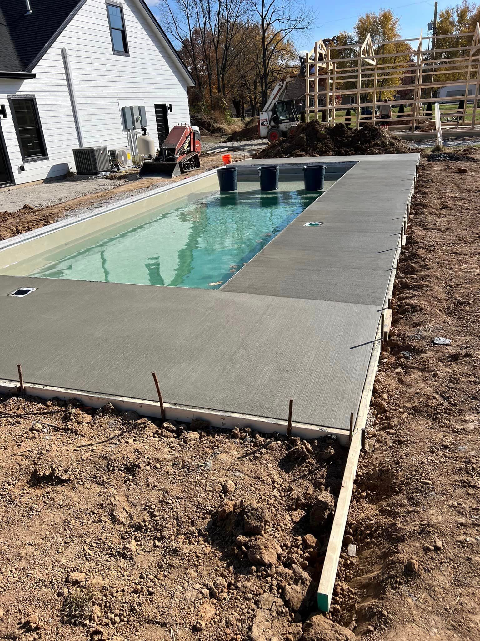 A swimming pool is being built in the backyard of a house.