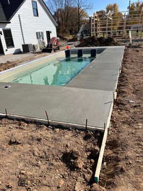 A swimming pool is being built in the backyard of a house.