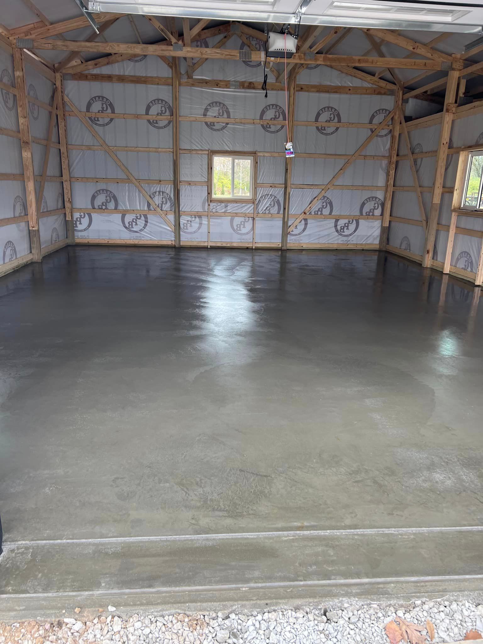 A garage with a concrete floor and a wooden structure.