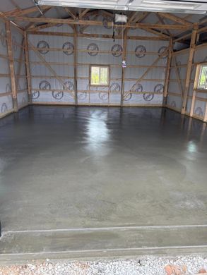 A garage with a concrete floor and a wooden structure.