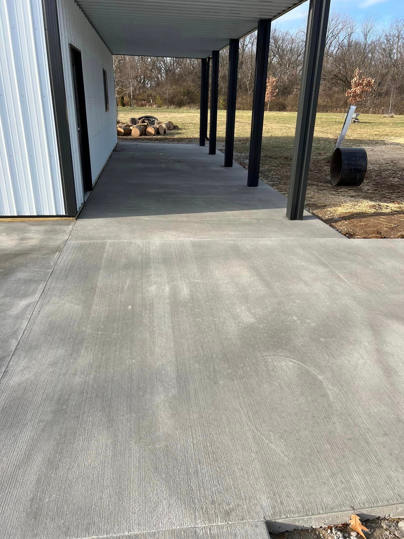 A concrete walkway leading to a building with a covered porch.