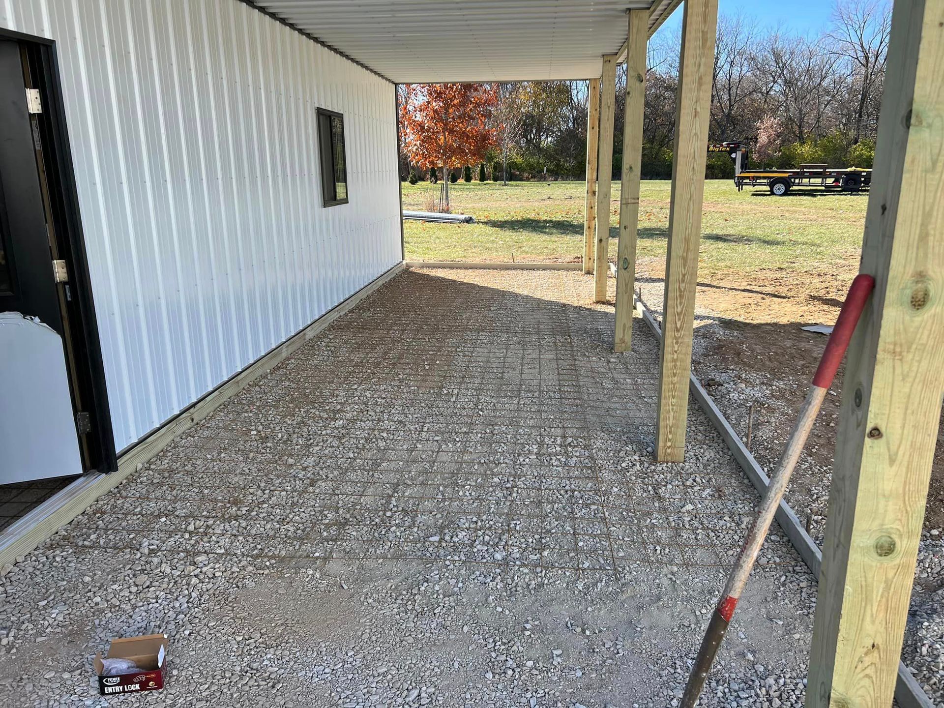 A shovel is sitting on the ground in front of a building.