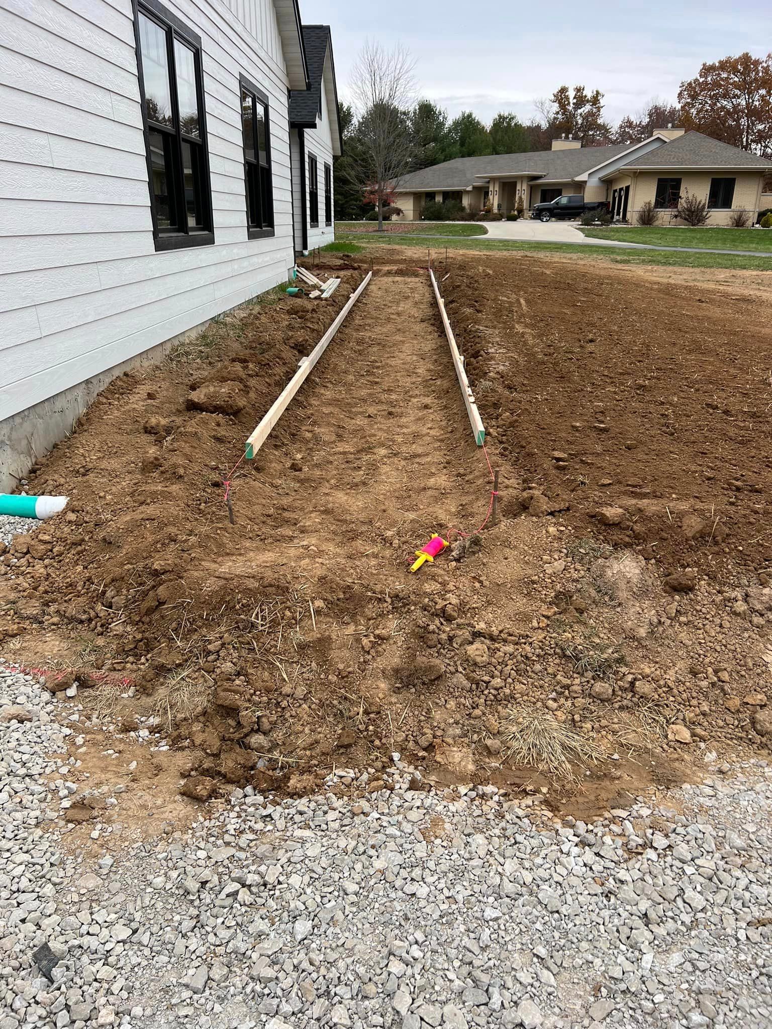 A dirt road is being built in front of a house.