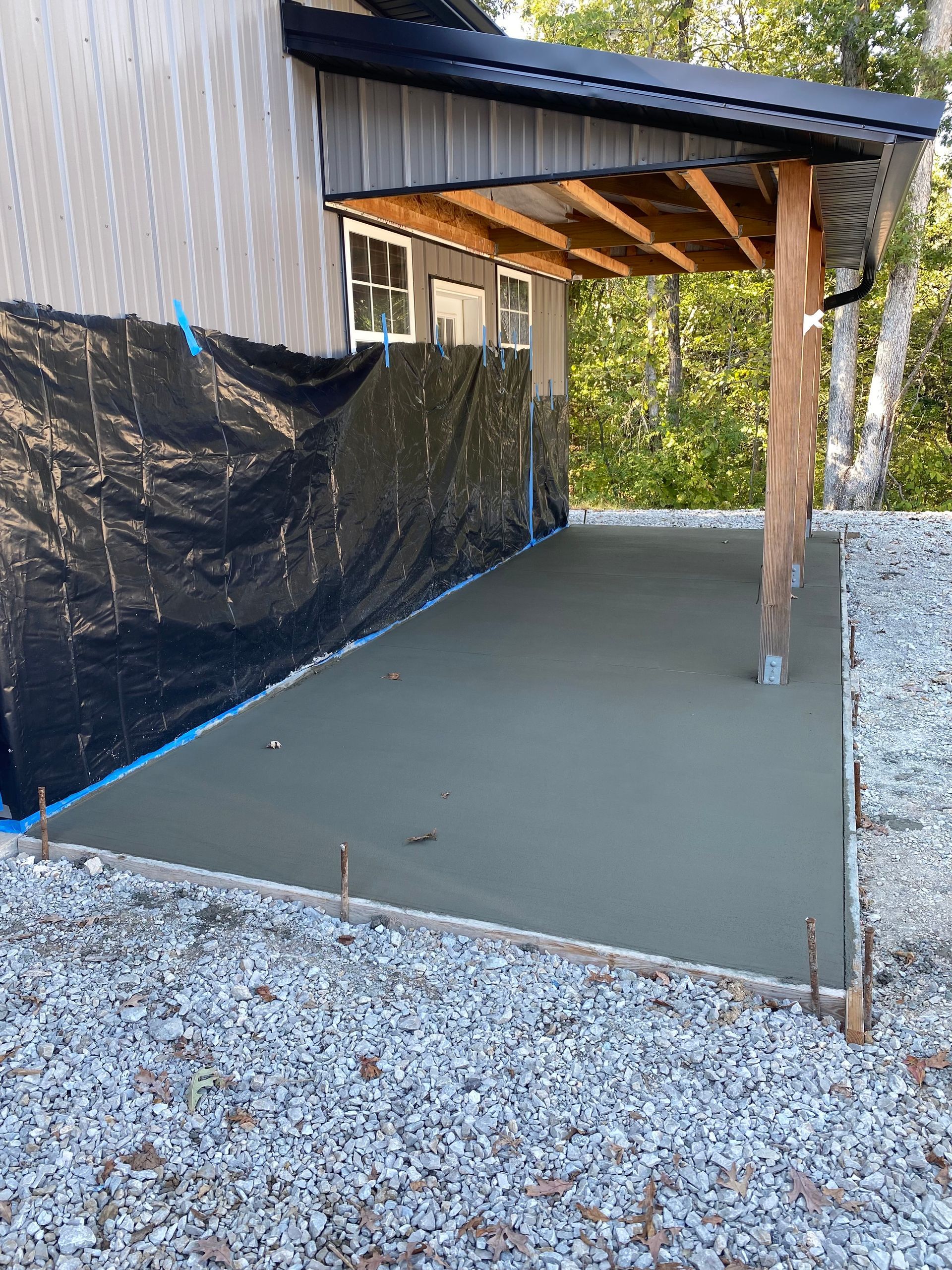 A concrete driveway is being built in front of a house.