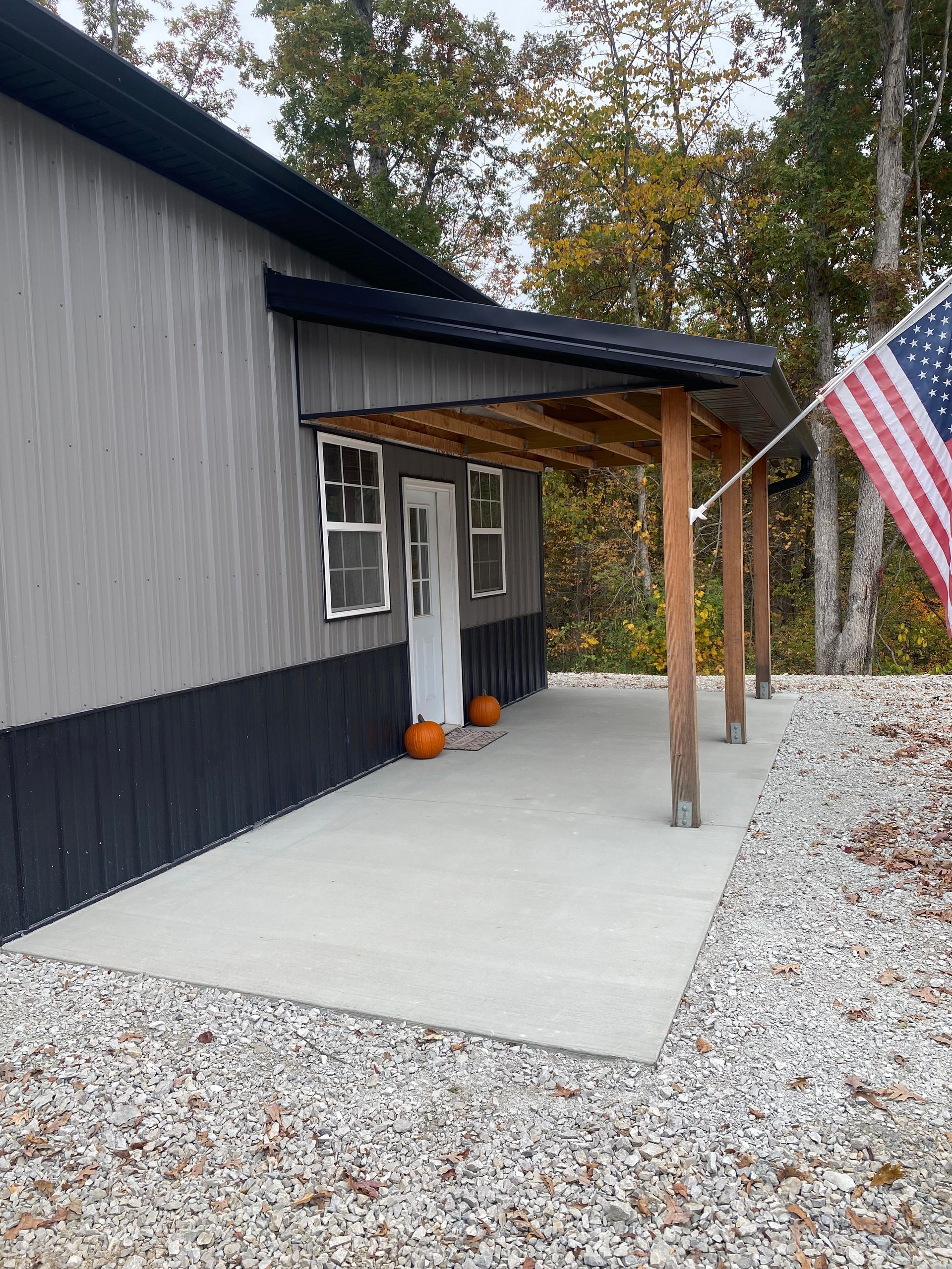 A house with a porch and an american flag hanging from it.