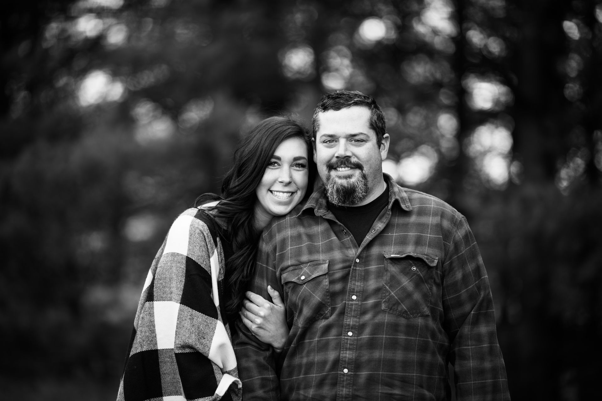 a black and white photo of a man and a woman standing next to each other .