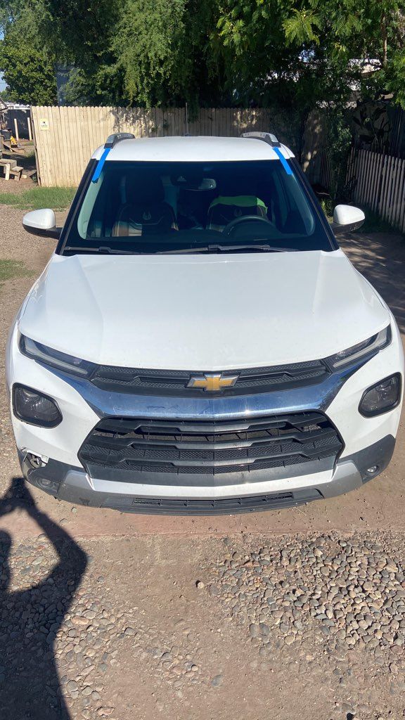 White Chevrolet SUV parked outdoors, with blue tape on the windshield.