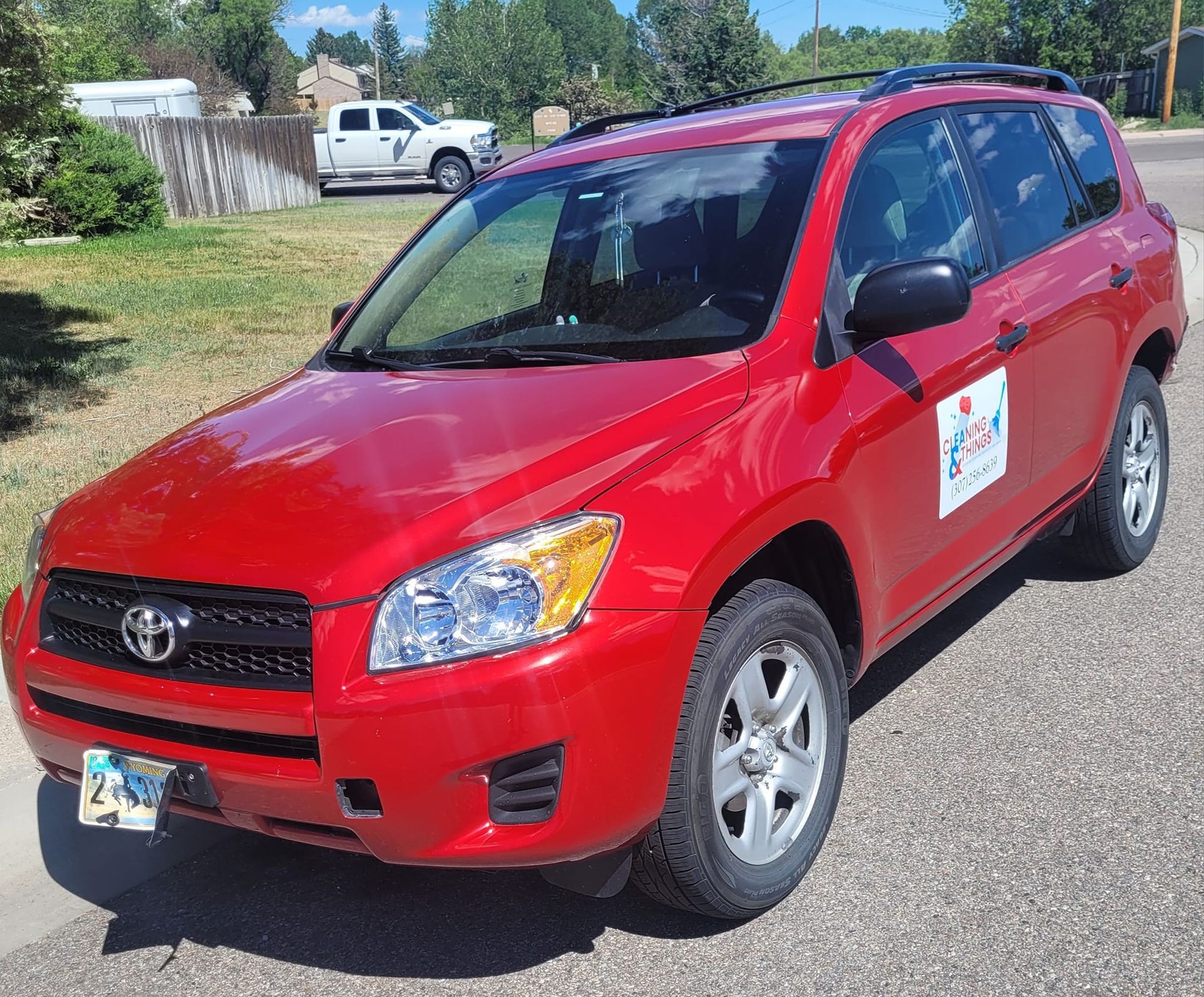 A red toyota rav4 is parked on the side of the road