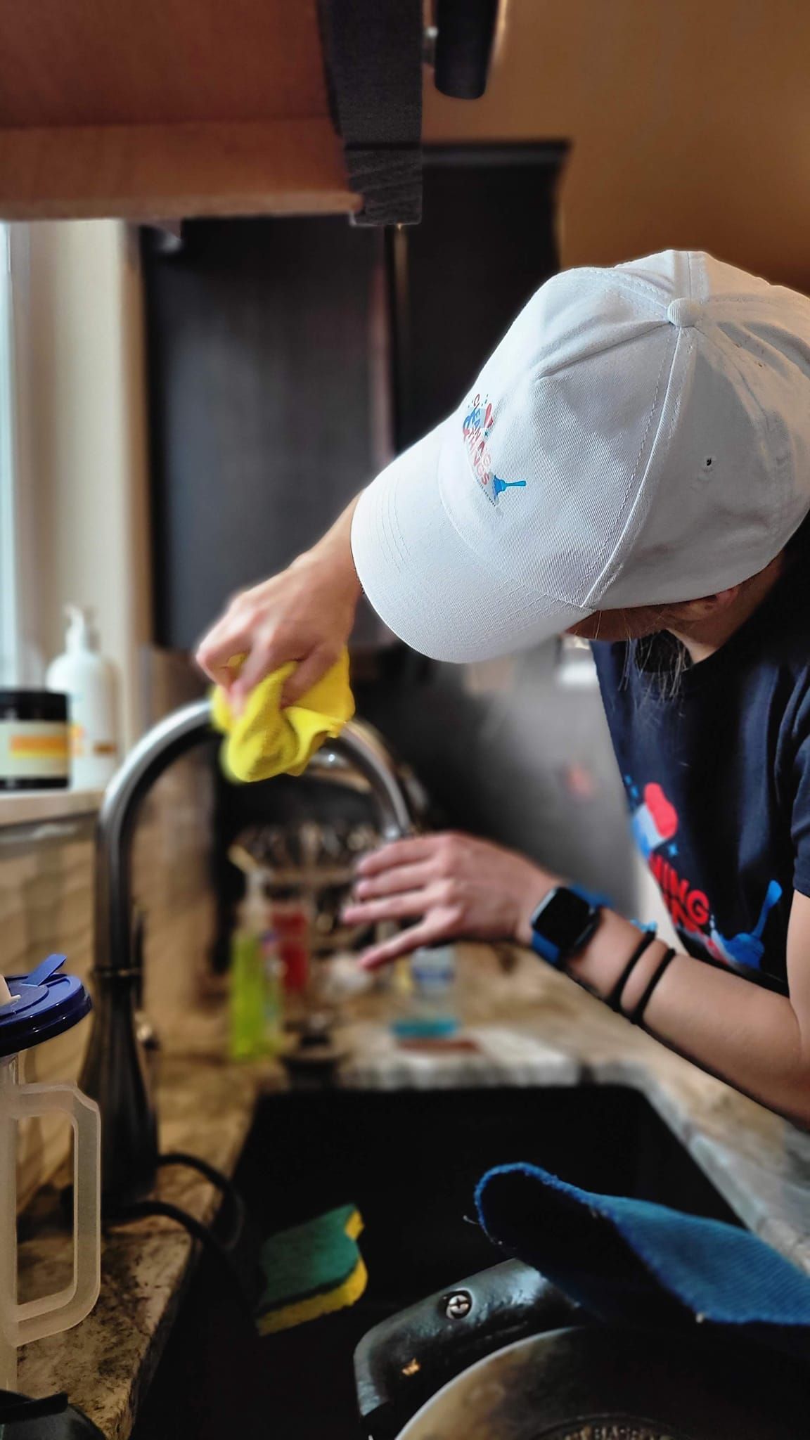 A person is washing dishes in a kitchen sink.