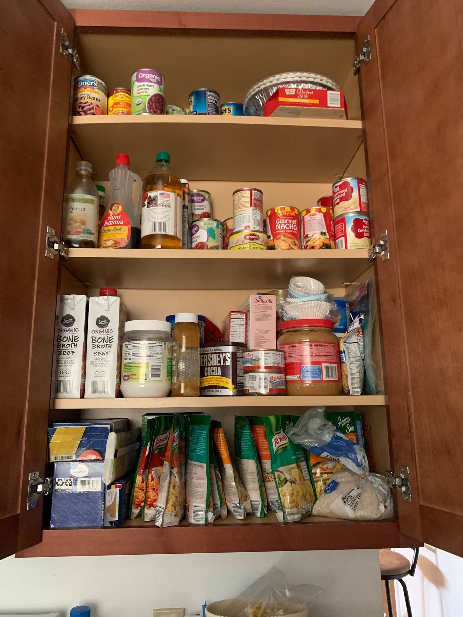 A kitchen cabinet filled with lots of food and drinks.