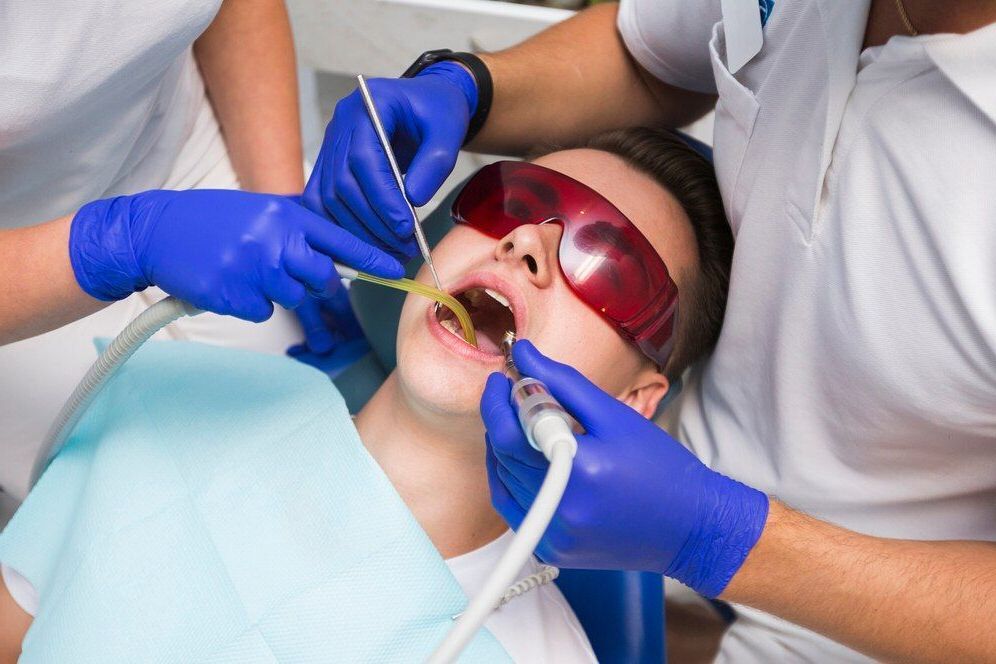 A young boy is getting his teeth clean by a dentist.
