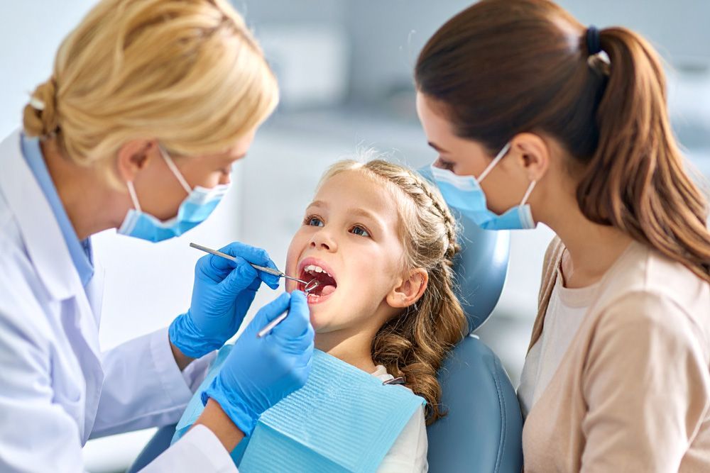 Dentist examining a young girl's teeth in Meridian, ID