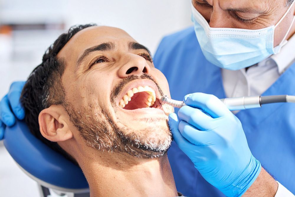 Dentist cleaning patient's teeth  in Meridian, ID