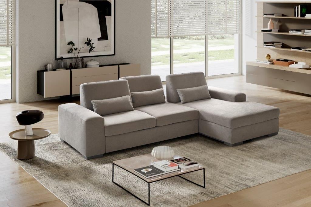 Un soggiorno moderno con un divano componibile grigio chiaro su un tappeto a fantasia.