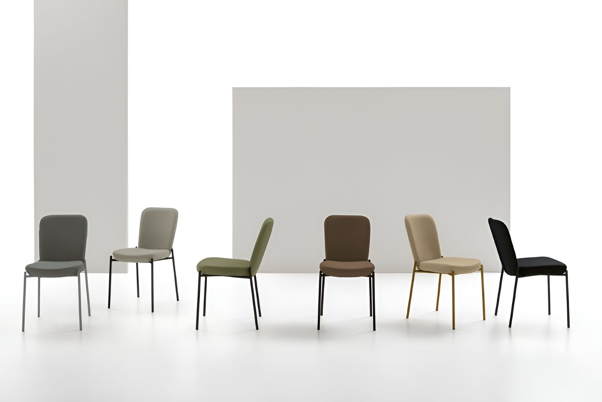 Sette sedie moderne di vari colori su sfondi bianchi.