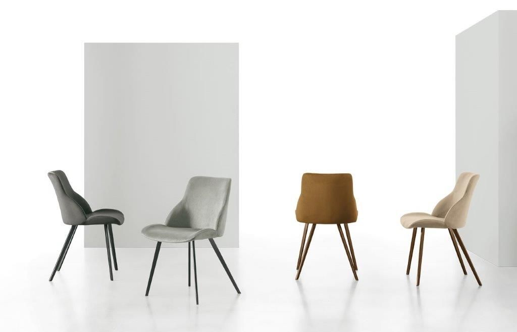 Quattro sedie da pranzo moderne nei toni del grigio, del beige e del marrone su uno sfondo bianco.
