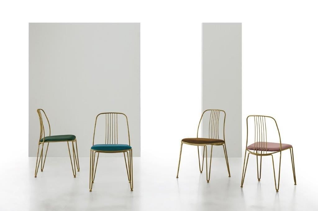 Quattro sedie con struttura dorata e sedute colorate su uno sfondo bianco.