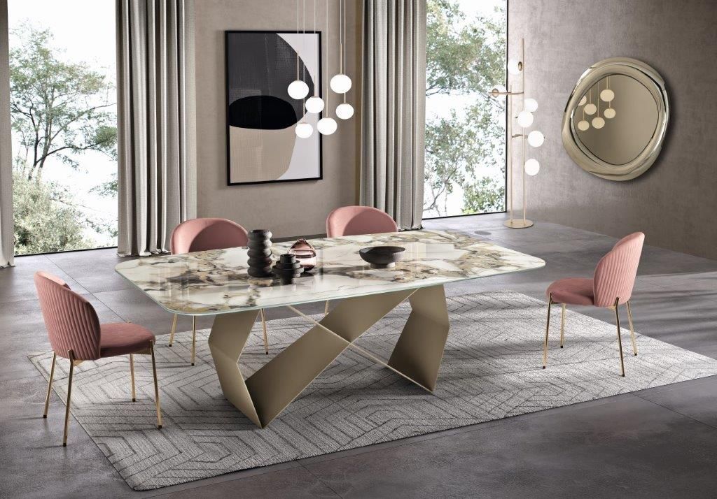 Sala da pranzo con tavolo in marmo, sedie rosa, opere d'arte astratte e dettagli dorati.