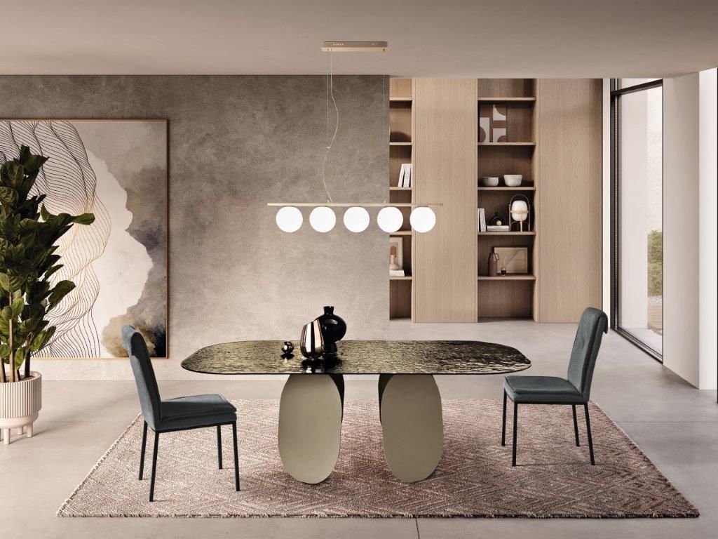 Sala da pranzo con un tavolo moderno, due sedie, un tappeto e opere d'arte.