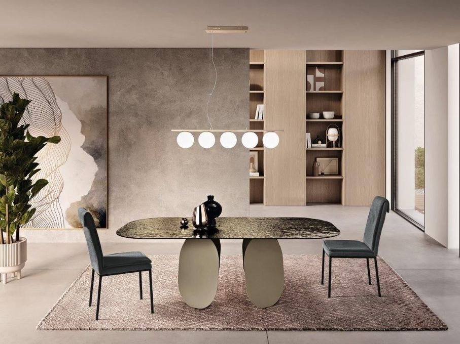 Sala da pranzo con un tavolo moderno, due sedie, un tappeto e opere d'arte.