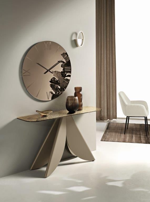 Consolle con orologio e oggetti decorativi contro una parete. Combinazione di colori beige e marrone.