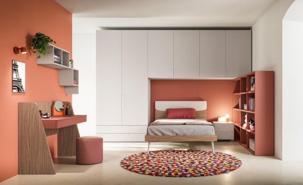 Camera da letto nei toni del corallo con letto, scrivania, spazio contenitore e libreria.