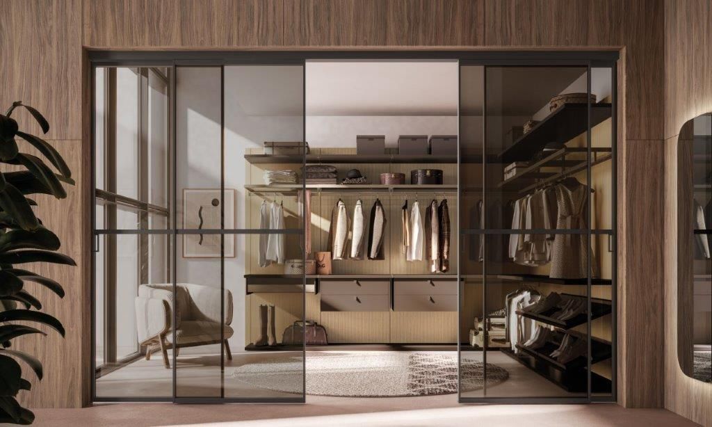 Cabina armadio con porte scorrevoli in vetro, appendiabiti, ripiani e pannelli in legno.
