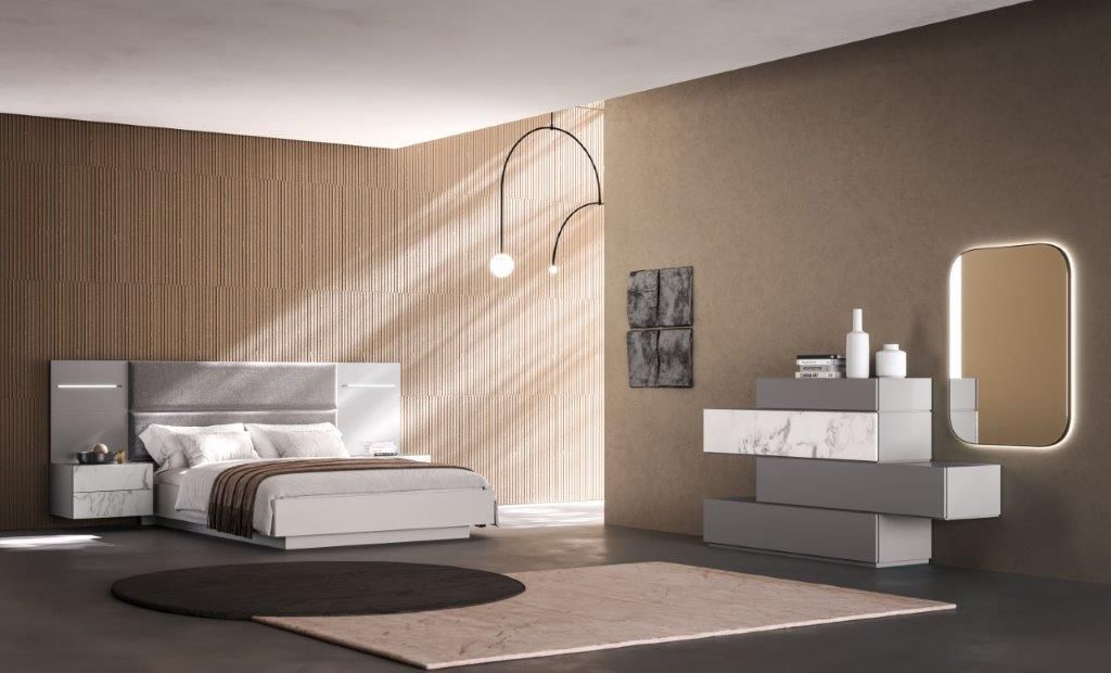 Camera da letto moderna con letto, cassettiera, specchio, tappeto e lampada a sospensione.