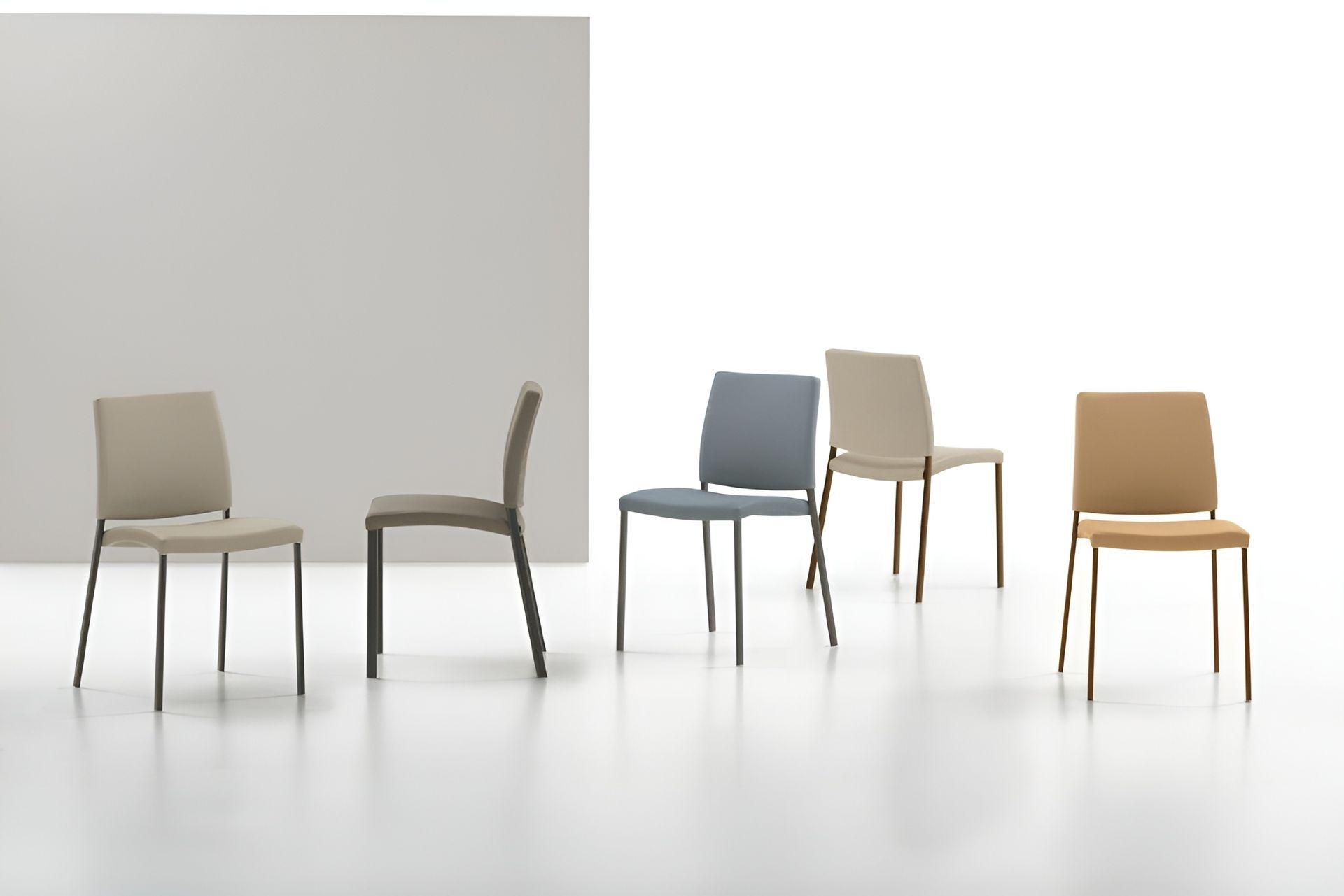 Cinque sedie moderne con gambe in metallo e sedute di vari colori su uno sfondo bianco.