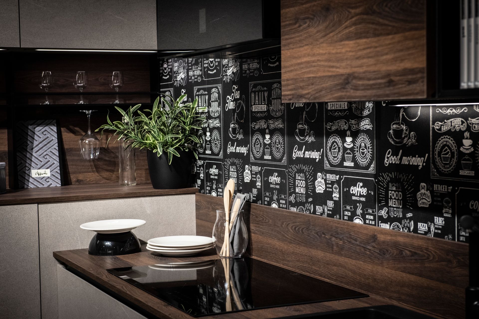 Cucina moderna con mobili in legno scuro, paraschizzi nero in stile lavagna e arredamento minimalista.