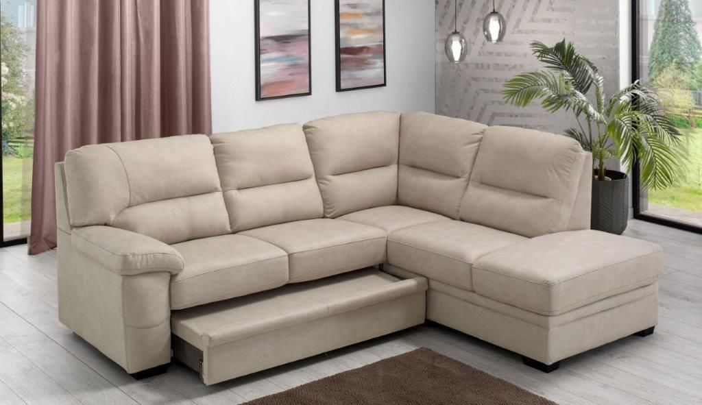 Divano componibile beige in un soggiorno, cassetto del letto estraibile a vista, con opere d'arte e piante.