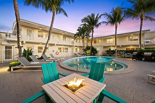 A swimming pool with a fire pit in the middle of it